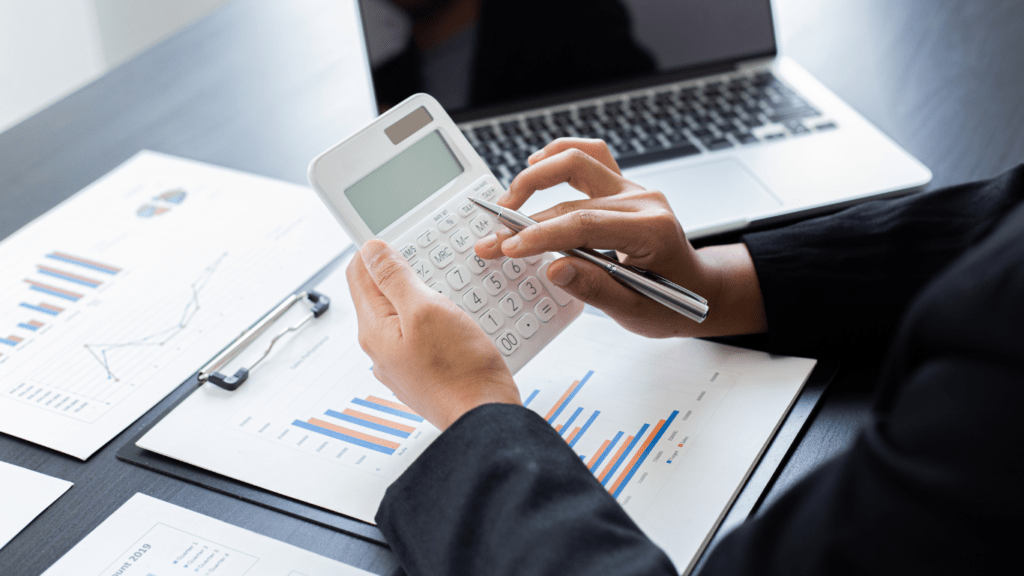 A person in a business suit is using a calculator.