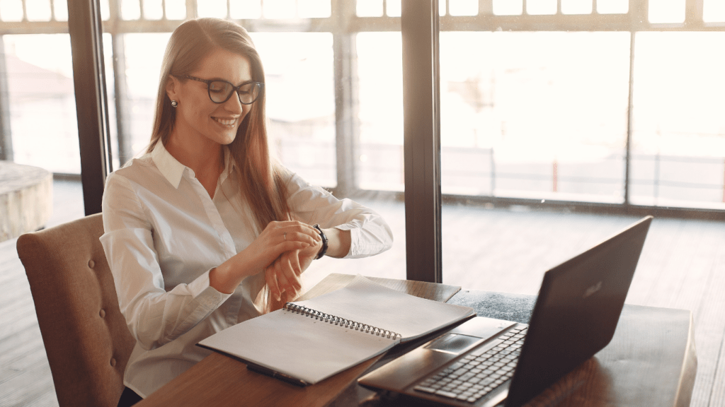 A person in glasses sitting at a table with a laptop