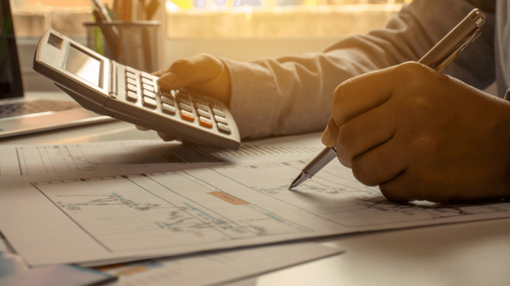 A person in a business suit is using a calculator.
