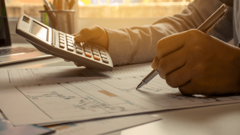 A person in a business suit is using a calculator.