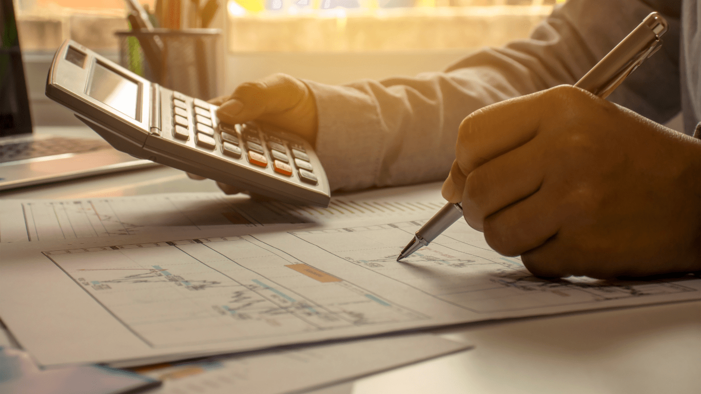 A person in a business suit is using a calculator.