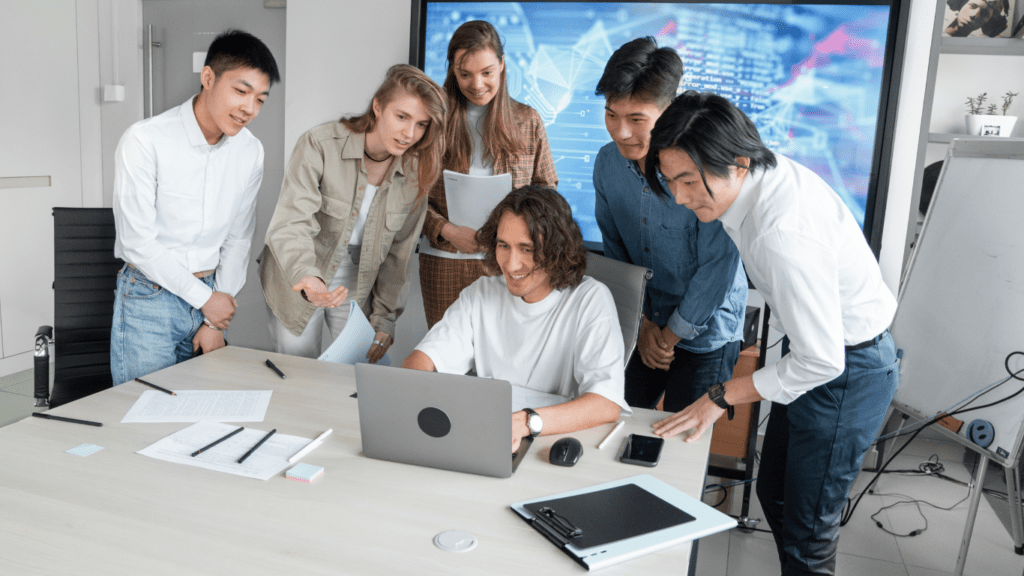 a group of people working together on a laptop