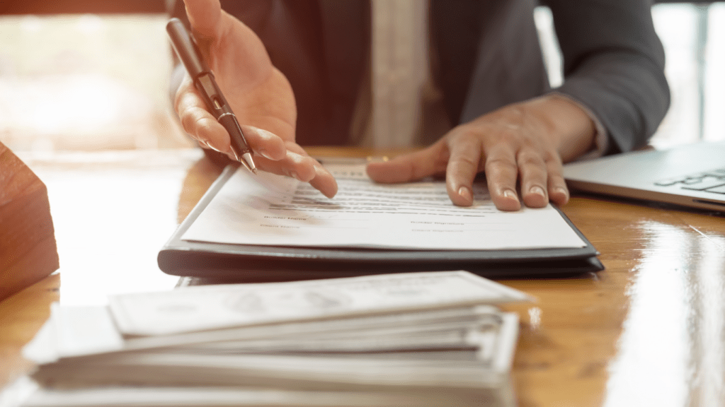 A person in a suit sitting at a desk with a scale of justice.