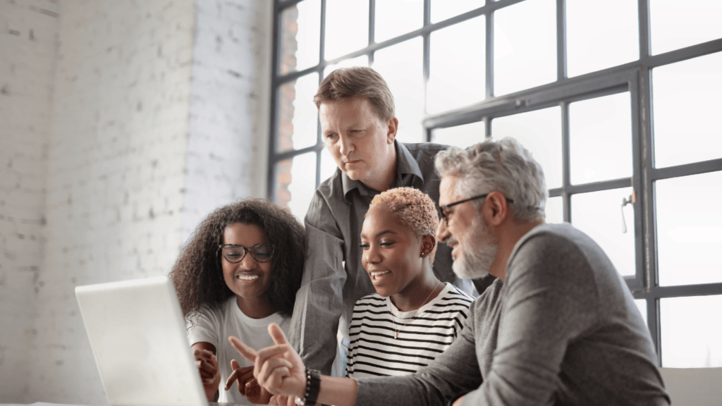 a group of people working together on a laptop